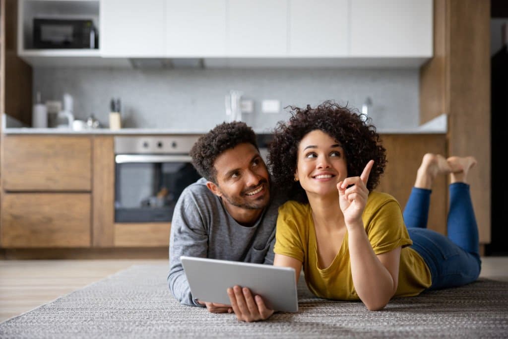 Couple pensant à la décoration de leur maison à l’aide d’une application sur une tablette